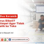 Seorang pria sedang berjongkok mengukur luas lantai menggunakan meteran di dalam toko keramik yang luas