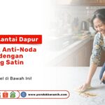 Seorang wanita membersihkan tumpahan minyak pada Solusi Lantai Dapur: Keramik Anti-Noda Minyak dengan Finishing Satin