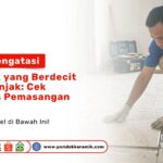 Seorang teknisi memakai sarung tangan kain sedang memeriksa kualitas pemasangan dan Mengatasi Keramik Berdecit Diinjak di Toko Pondok Keramik